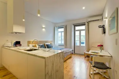 a kitchen with a counter top and a living room at Flower 45 Suite @ Rua das Flores in Porto