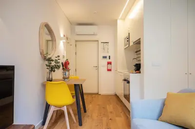 a small kitchen with a table and a yellow chair at Golden Factory Apartment Downtown, Terrace and AC in Porto