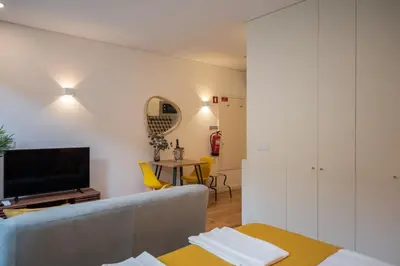 a living room with a couch and a table at Golden Factory Apartment Downtown, Terrace and AC in Porto