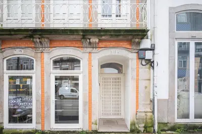 a building with a white door and two windows at Golden Factory Apartment Downtown, Terrace and AC in Porto