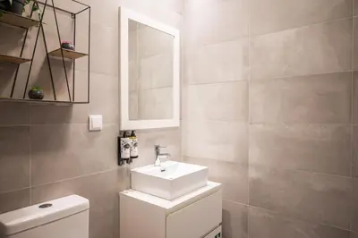a bathroom with a sink and a toilet and a mirror at Golden Factory Apartment Downtown, Terrace and AC in Porto