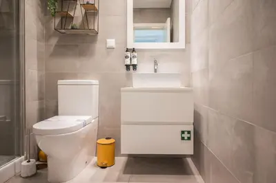 a bathroom with a white toilet and a sink at Golden Factory Apartment Downtown, Terrace and AC in Porto