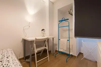 a small room with a bed and a desk at Taipas Guest House in Porto
