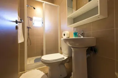 a bathroom with a toilet and a sink and a shower at Taipas Guest House in Porto