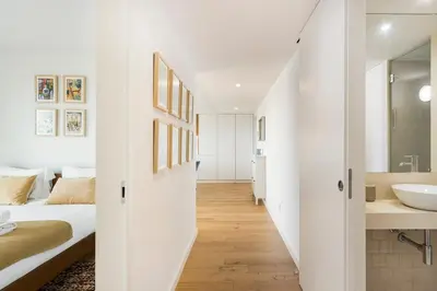 a bedroom with a bed and a bathroom with a sink at GuestReady - Central Park in Porto in Porto