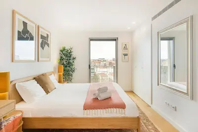 a bedroom with a large bed and two windows at GuestReady - Central Park in Porto in Porto