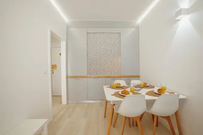 a white dining room with a white table and chairs at Santa Catarina Apartment by Hosty in Porto