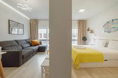 a bedroom and living room with a bed and a couch at Santa Catarina Apartment by Hosty in Porto