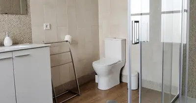 a bathroom with a toilet and a glass shower at Casa do Recanto - Private Suite in Porto