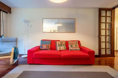 a red couch sitting in a living room at Casa Jardim by LovelyStay in Porto