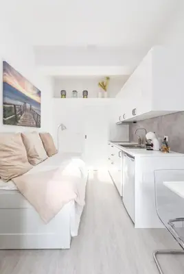 a white room with a bed and a kitchen at Studio de luxo no Porto - T0 in Porto