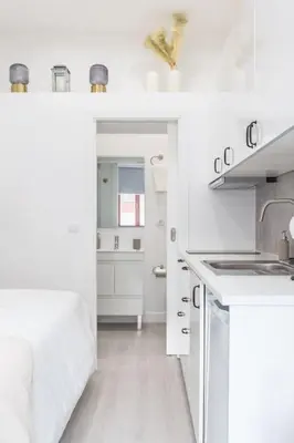 a white kitchen with a bed and a sink at Studio de luxo no Porto - T0 in Porto