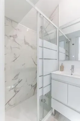 a white bathroom with a sink and a mirror at Studio de luxo no Porto - T0 in Porto