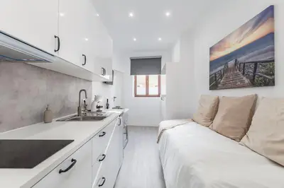 a white kitchen with a couch and a sink at Studio de luxo no Porto - T0 in Porto