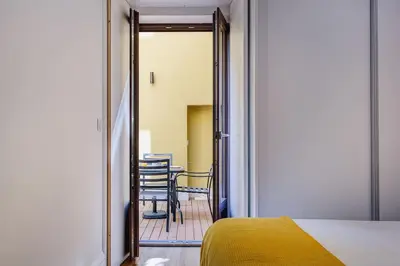 a room with a bed and a table and chairs at Cais das Pedras Terrace by Cozy Stay in Porto
