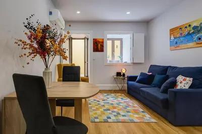 a living room with a blue couch and a table at Cais das Pedras Terrace by Cozy Stay in Porto