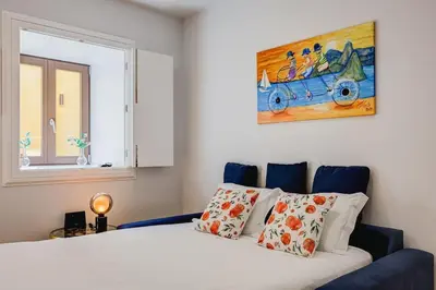 a bedroom with a bed and a painting on the wall at Cais das Pedras Terrace by Cozy Stay in Porto