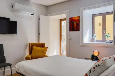 a bedroom with a large white bed and a window at Cais das Pedras Terrace by Cozy Stay in Porto