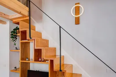 a wooden staircase in a home with a white wall at Cais das Pedras Duplex by Cozy Stay in Porto