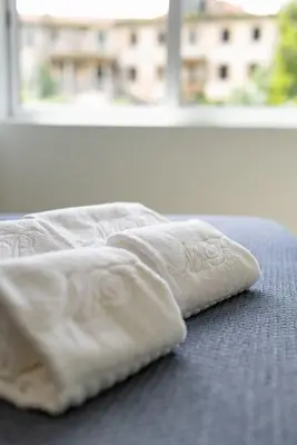 a white pillow sitting on a bed with a window at Lu's Douro View Apartment in Vila Nova de Gaia