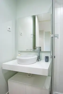 a white bathroom with a sink and a mirror at Lu's Douro View Apartment in Vila Nova de Gaia
