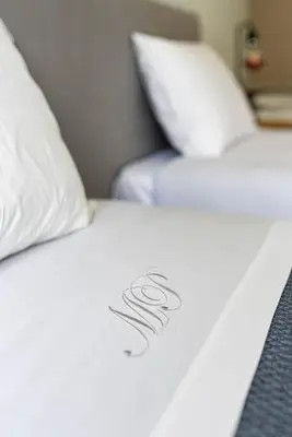 a close up of a bed with white sheets and pillows at Lu's Douro View Apartment in Vila Nova de Gaia