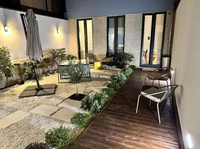 a patio with a umbrella and chairs and plants at Douro Premium Garden by MP in Vila Nova de Gaia