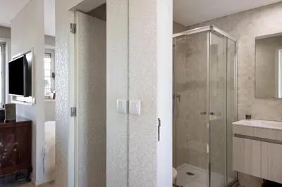 a bathroom with a glass shower and a sink at The Plaza Boavista in Porto