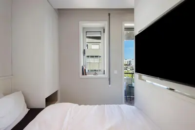 a bedroom with a bed and a flat screen tv at The Plaza Boavista in Porto