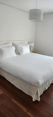 a large white bed with white sheets and pillows at Cedofeita Sunny Apartment - Balcony & Parking in Porto