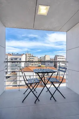 a table and chairs on a balcony with a view at Cedofeita Sunny Apartment - Balcony & Parking in Porto