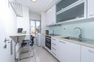 a kitchen with white cabinets and a sink at Cedofeita Sunny Apartment - Balcony & Parking in Porto