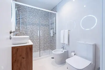 a bathroom with a toilet and a sink and a shower at Cedofeita Sunny Apartment - Balcony & Parking in Porto