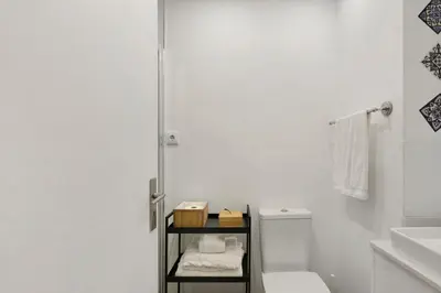 a white bathroom with a toilet and a shower at Seni's House in Porto