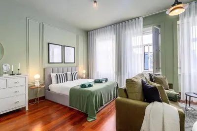 a living room with a couch and a table and chairs at Maison d'Angelina: in the heart of Porto in Porto
