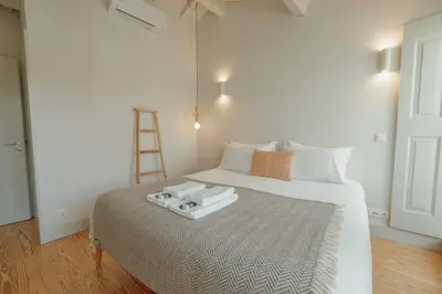 a bedroom with a white bed with a ladder on it at Deluxe Duplex by Hosty in Porto