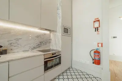 a kitchen with white cabinets and a stove top oven at Deluxe Duplex by Hosty in Porto