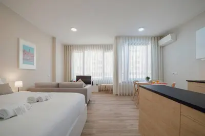 a hotel room with a bed and a living room at Trindade Deluxe by Hosty in Porto