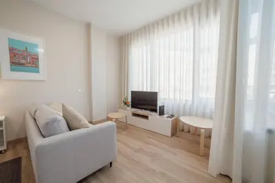 a living room with a white couch and a television at Trindade Deluxe by Hosty in Porto