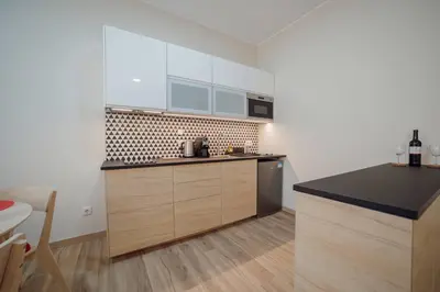 a kitchen with wooden cabinets and a black counter top at Trindade Deluxe by Hosty in Porto