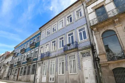 a building with white doors and windows on a street at Oporto Sunset Blue Balcony in Porto