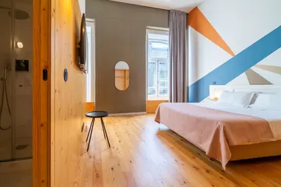 a bedroom with a bed with an orange and blue accent wall at Limehome Porto Rua da Conceicao in Porto