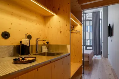 a kitchen with wooden walls and a counter with a sink at Limehome Porto Rua da Conceicao in Porto