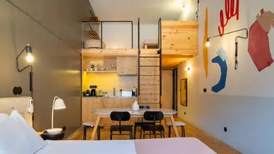 a room with a bed and a table and chairs at Limehome Porto Rua da Conceicao in Porto