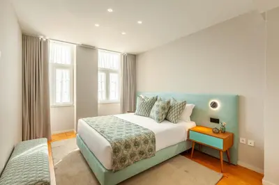 a bedroom with a large bed with a blue headboard at Savvy Signature Apartments in Porto