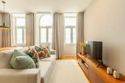 a living room with a couch and a flat screen tv at Savvy Signature Apartments in Porto