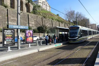 a train pulling into a train station with people waiting at Fervença Apartments in Vila Nova de Gaia