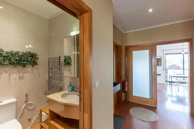 a bathroom with a sink and a mirror at Top floor apartment with Sunny Balconies in Porto