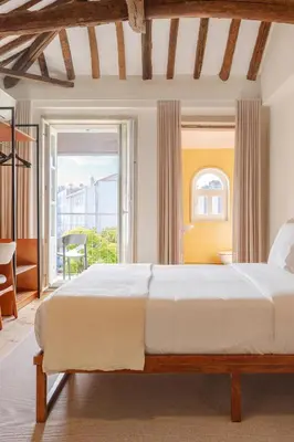 a bedroom with a bed and a desk and a kitchen at Rosário Suites Townhouse in Porto