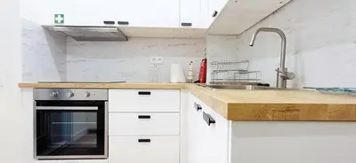 a kitchen with white cabinets and a sink at Lovling and Friendly with terrace in Porto